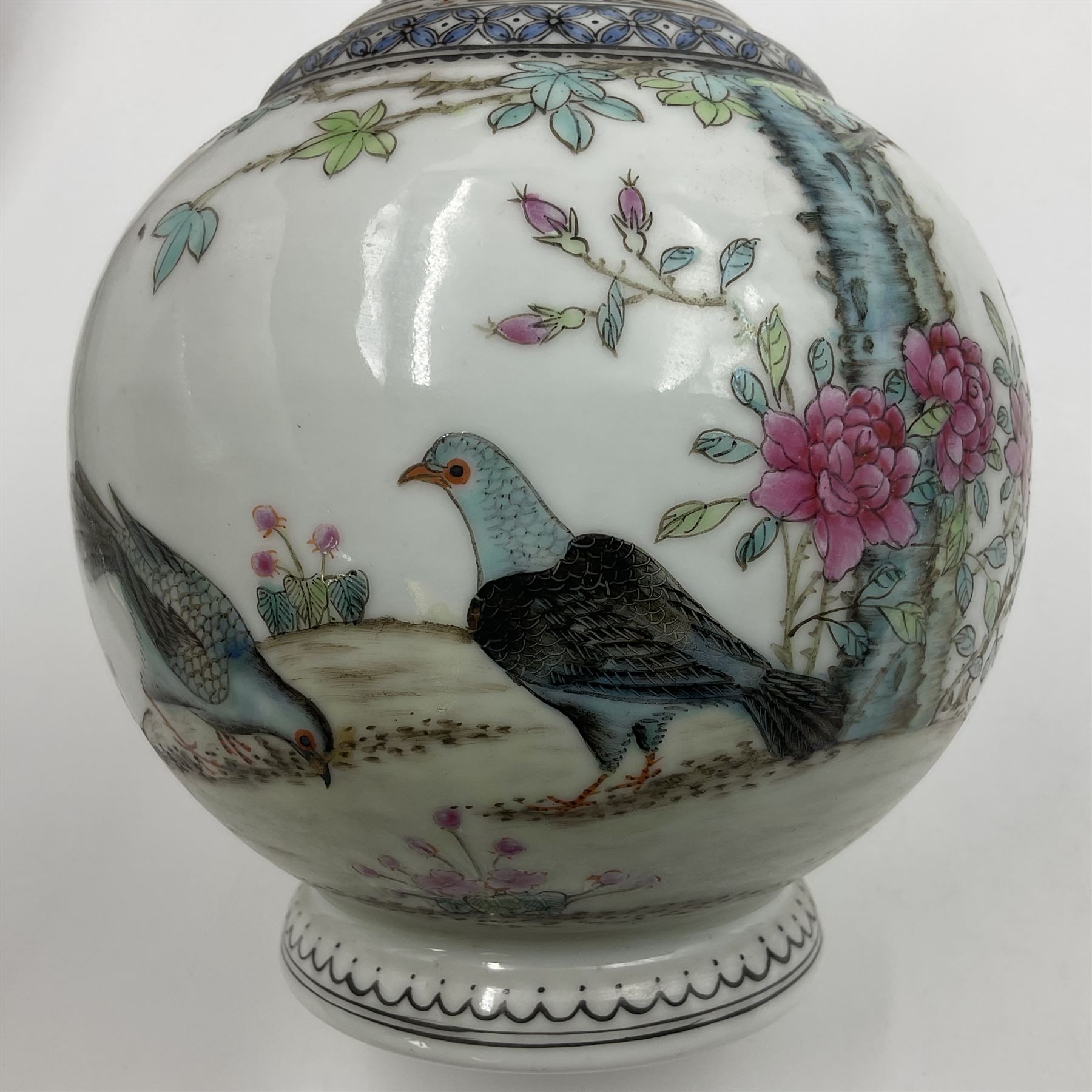 Pair of Chinese Republic porcelain vases, each painted in Famille Rose enamels with pairs of pigeons amidst peony, rock, flowering plants and leafy branches, possibly Qianlong seal beneath, H22cm 