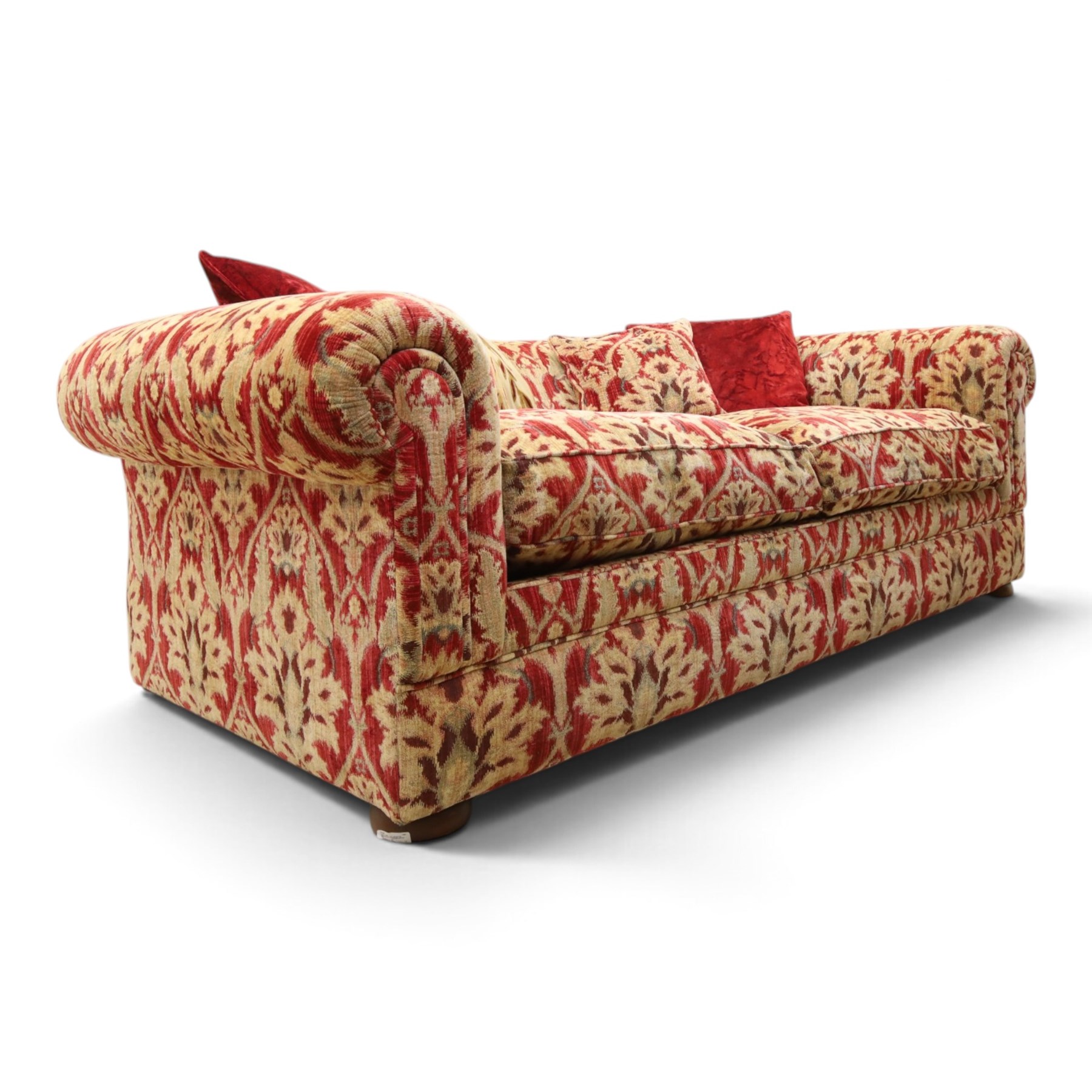Tetrad - grande two seat 'Elgar' sofa of traditional Chesterfield shape with rolled arms, upholstered in red and gold foliate patterned fabric with matching loose and scatter cushions, on compressed bun feet