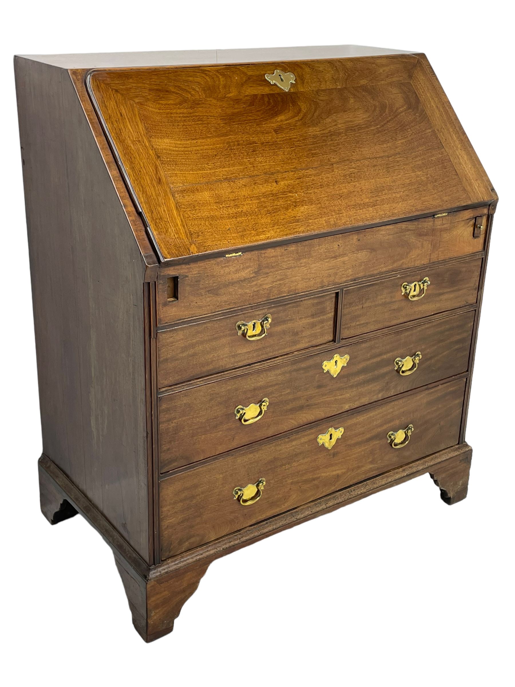 Georgian red walnut and mahogany bureau, moulded rectangular fall front with rounded upper corners, the interior fitted with sliding storage well, a combination of small drawers and pigeons holes, two short and two long drawers below, on bracket feet