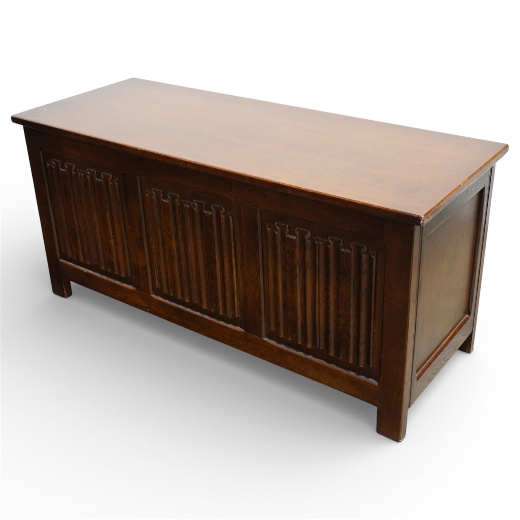 Late 20th century oak linenfold blanket box, with hinged rectangular top opening to a plain interior, the front carved with three linenfold panels, plain panelled sides, raised on stile supports