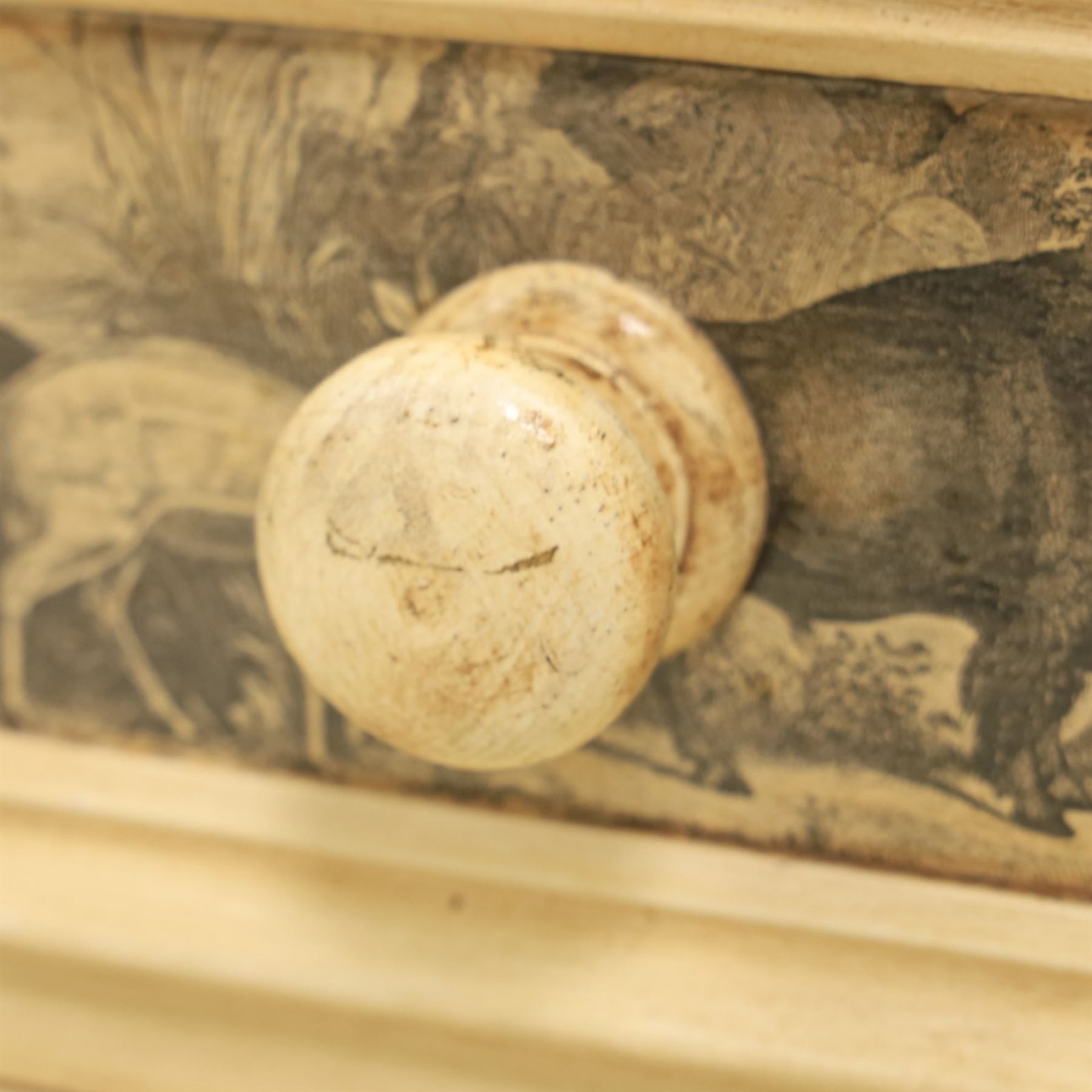 Traditional design cream painted lacquered pedestal chest, rounded moulded top over four short drawers, the drawer fronts decorated with monochrome printed animal scenes, conforming foliate and geometric borders to the top and sides, turned handles, on bun feet