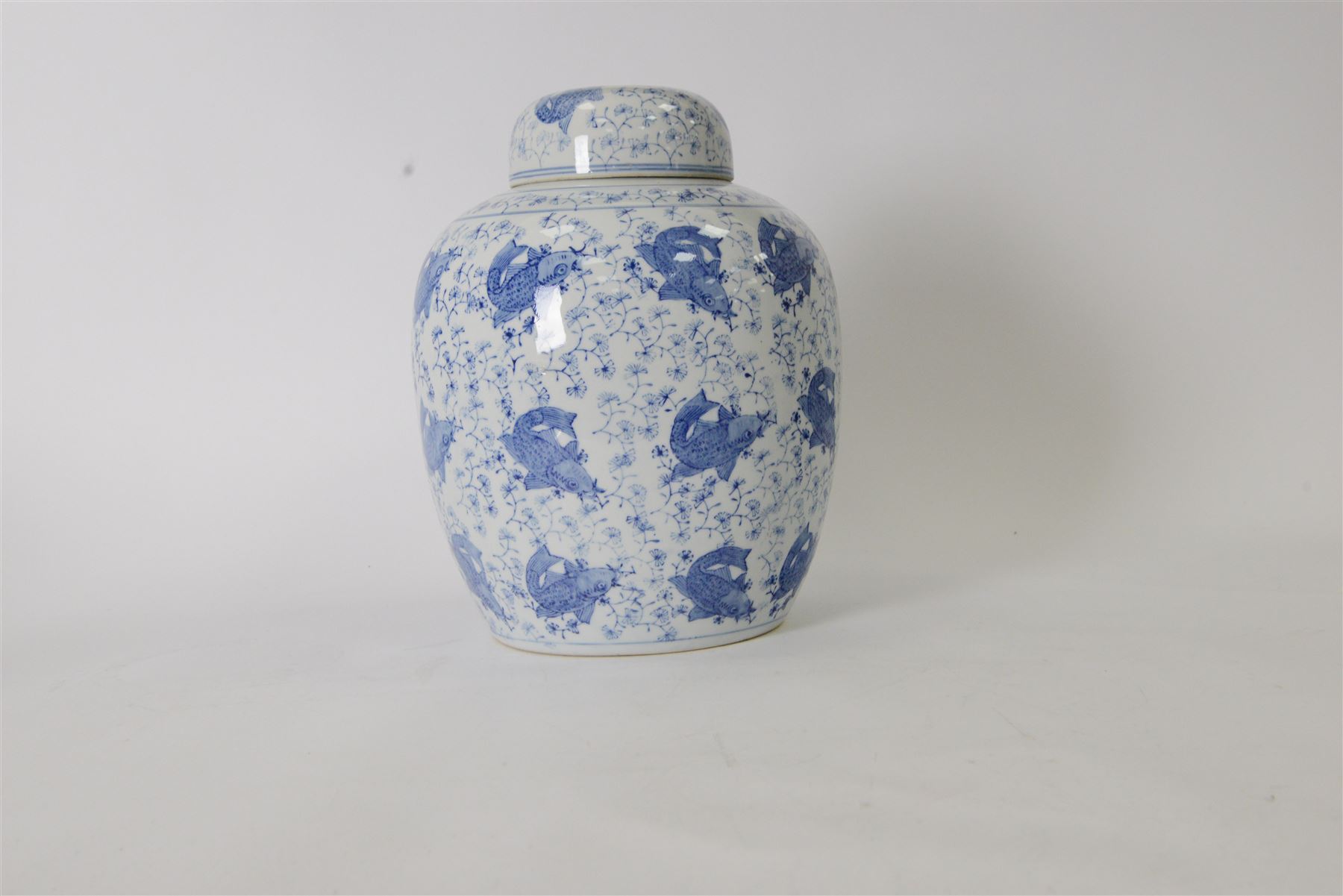 Blue and white ginger jar, decorated in a repetitive pattern of fish swimming amongst dense clusters of aquatic foliage, H40cm