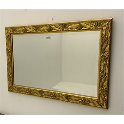 Bevelled edge wall mirror in gilt leaf and berry frame