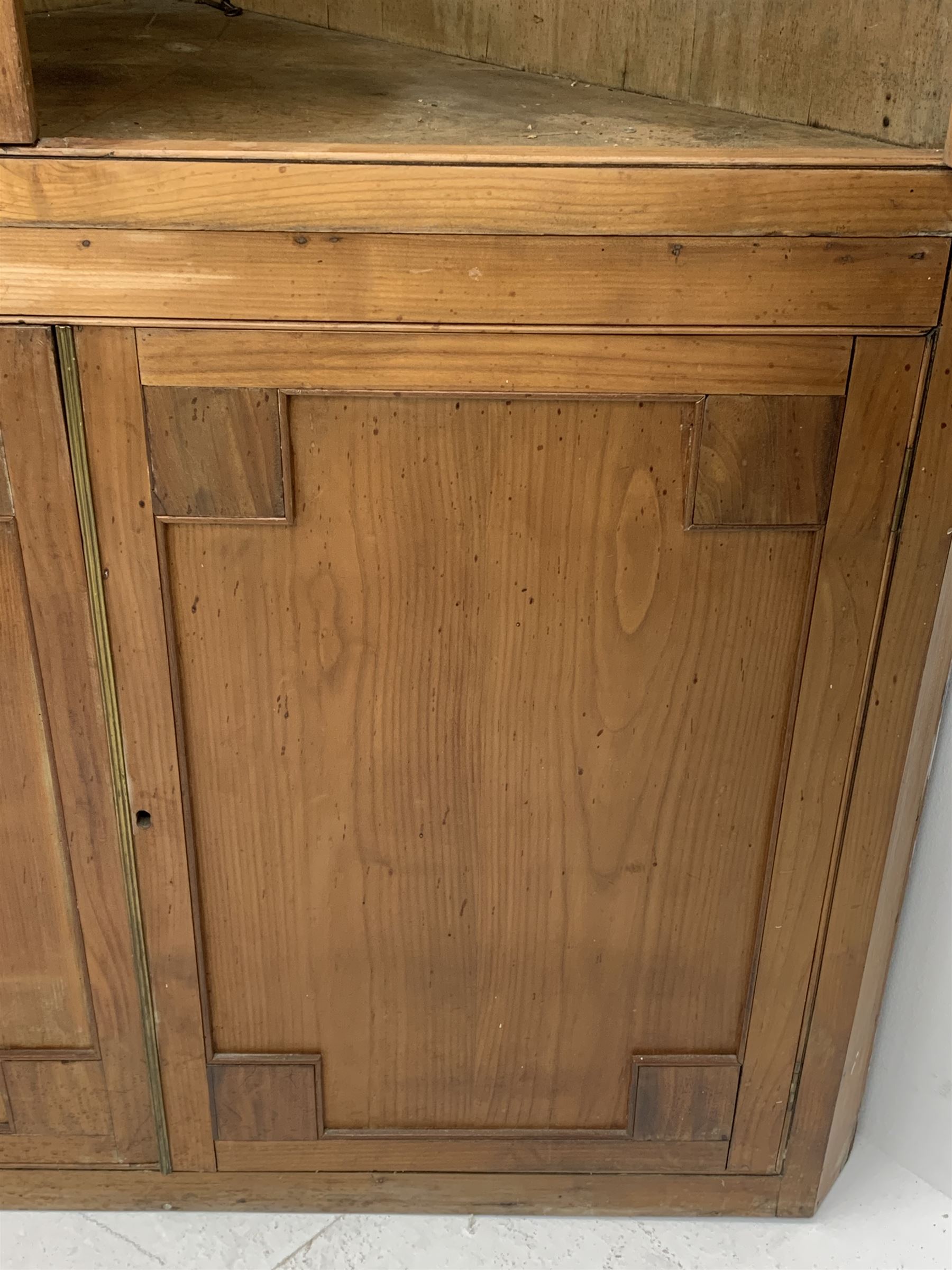Large late 19th century sycamore corner cabinet, the top section with two astragal glazed doors enclosing two shaped shelves, the lower section enclosed by two panelled doors with square spandrels, W128cm, H215cm