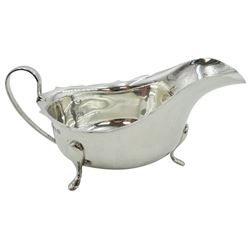 1930's silver sauce boat, of typical form with part shaped rim and curved handle, upon three pad feet, hallmarked Barker Brothers Silver Ltd, Birmingham 1936, together with a mid 20th century silver handled Queens pattern bread knife, hallmarked Viner's Ltd, Sheffield 1961, approximate gross weight 5.01 ozt (156 grams)