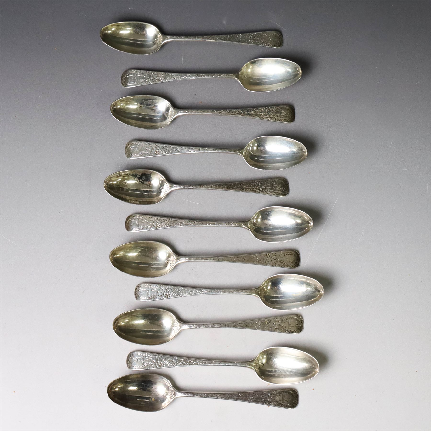 Eleven Victorian silver teaspoons, profusely engraved with floral decoration throughout with family crest to terminal, hallmarked Elkington & Co, Birmingham 1875