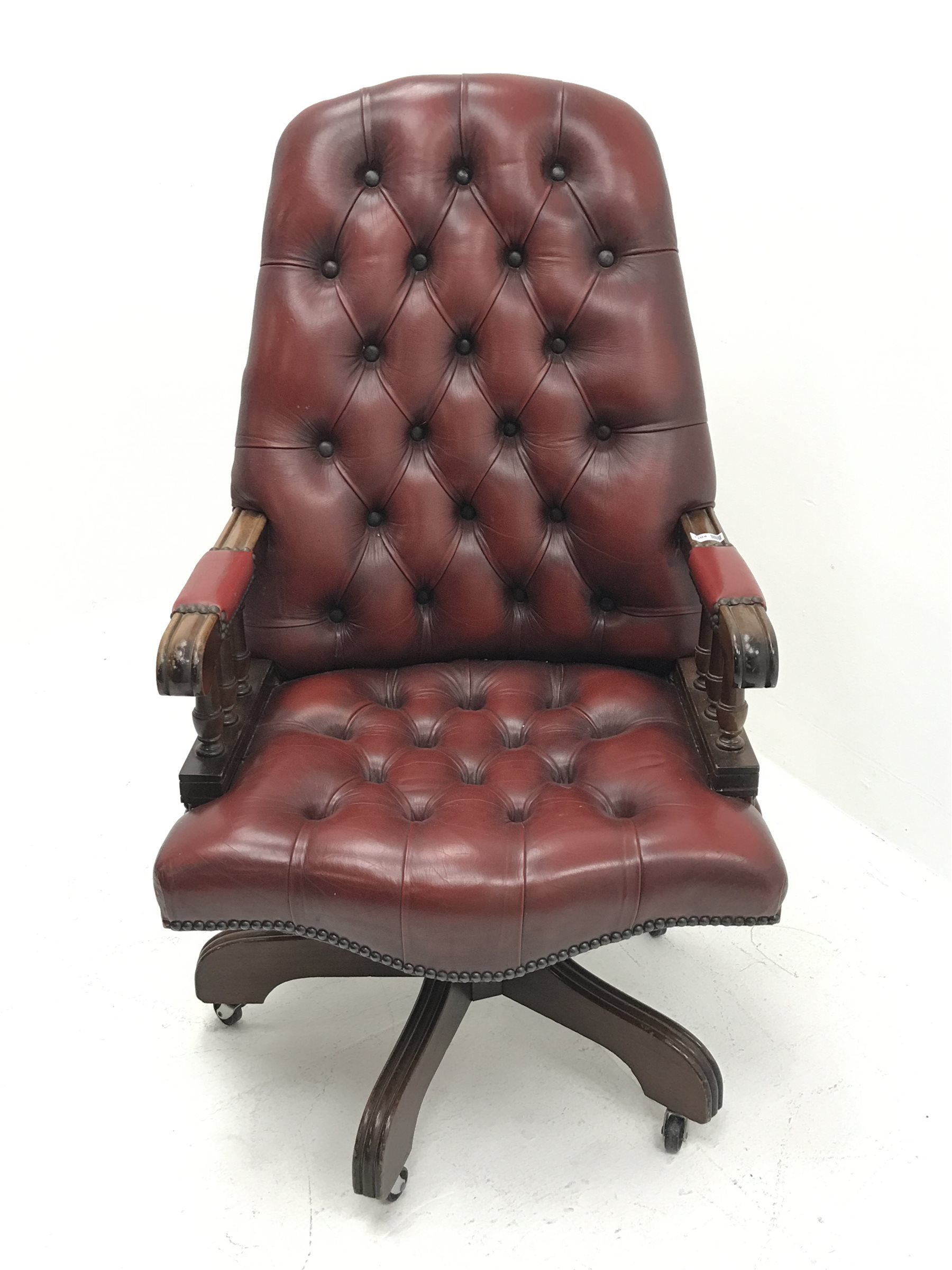 Swivel reclining desk chair upholstered in deep buttoned oxblood
