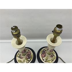 Pair of Moorcroft table lamps of candlestick form in magnolia pattern, with Moorcroft shades, H50cm 
