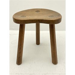 'Mouseman' oak three legged stool with dished kidney shaped seat, tapered octagonal supports, with carved mouse signature, by Robert Thompson of Kilburn 