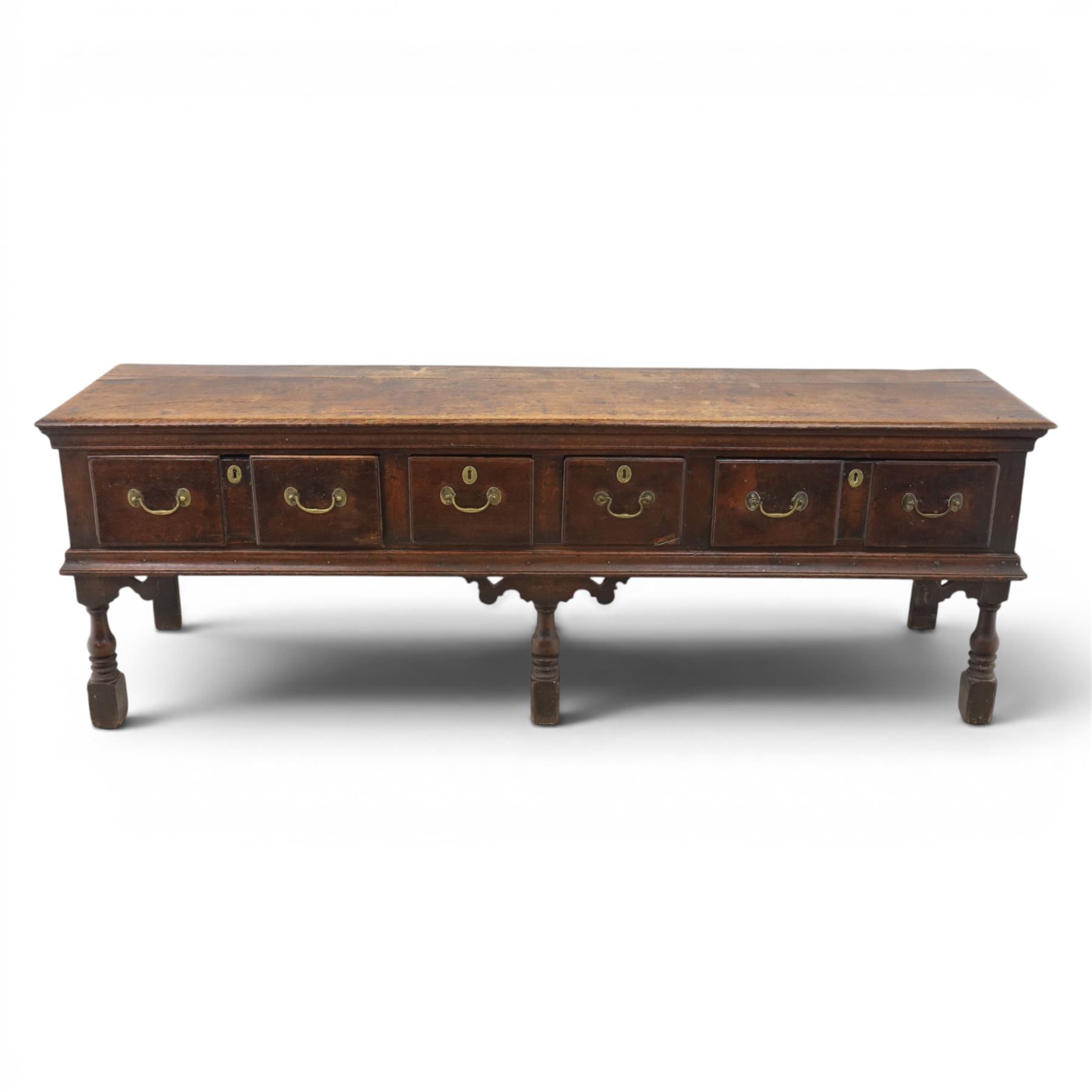 17th century 8’ oak dresser base with moulded front, rectangular top, above four drawers, raised on turned and block support 