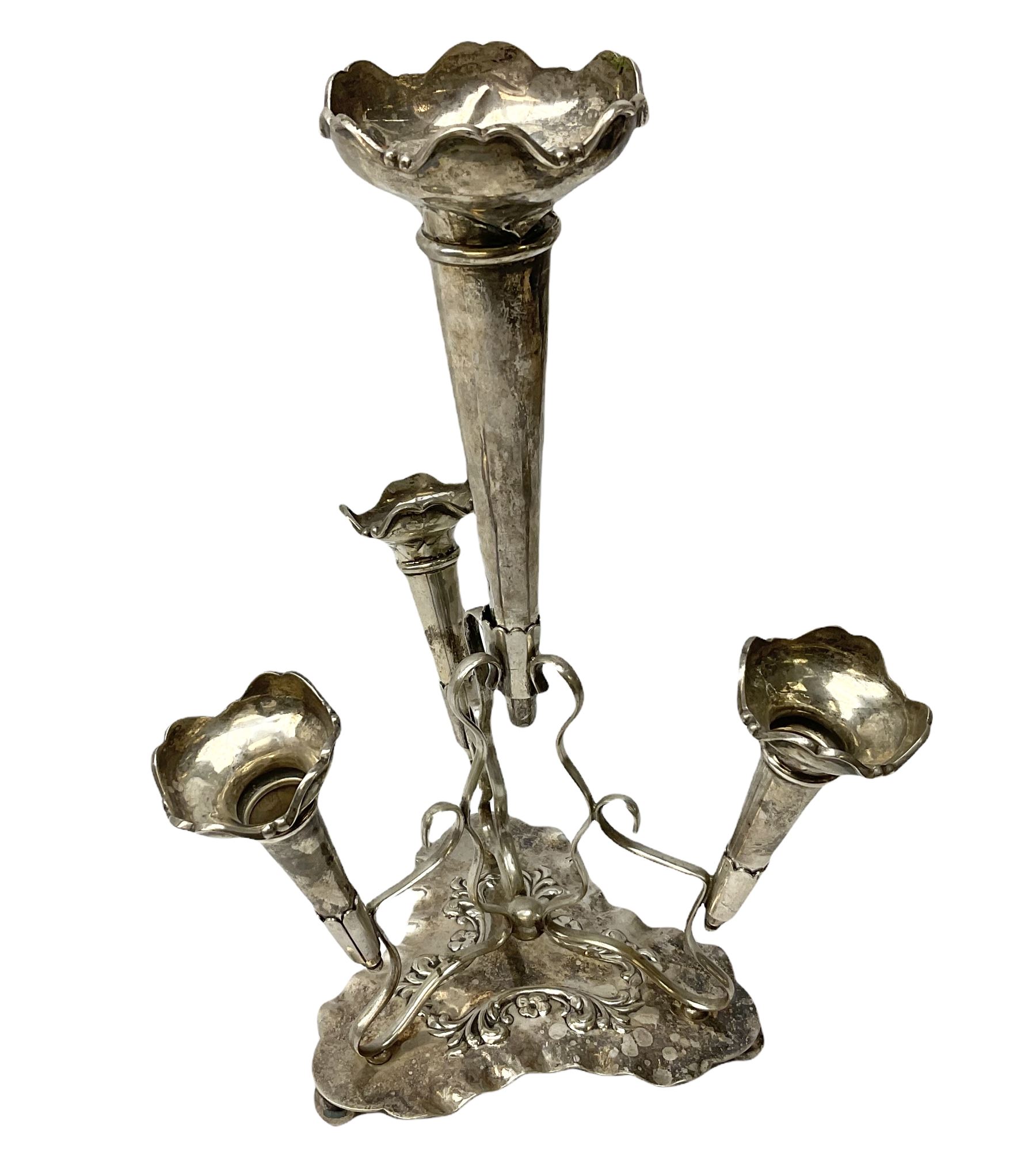 Four hallmarked silver trumpet vases, total weight 108g, upon silver plated stand with foliate decoration and bun feet