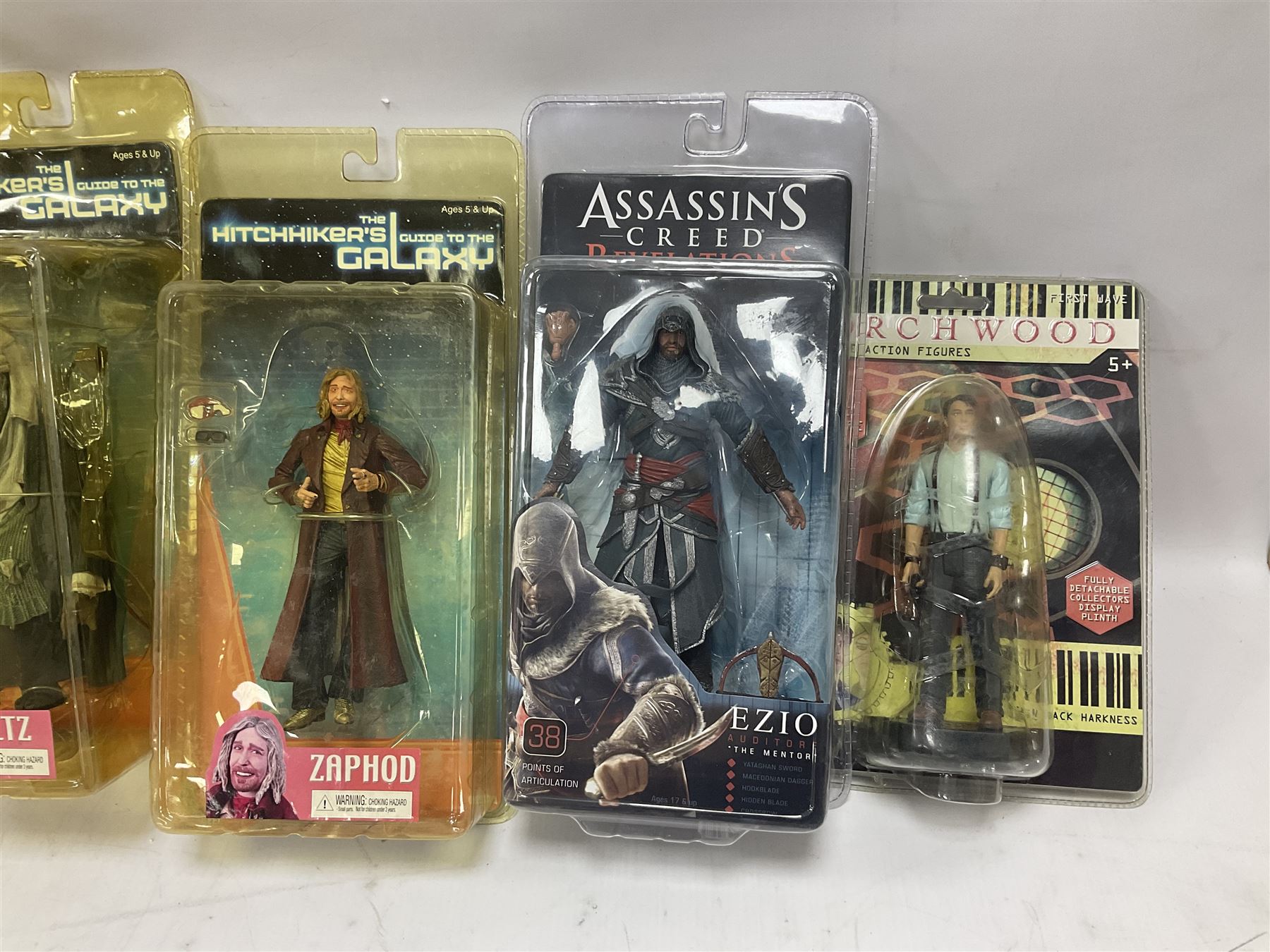 Sixteen carded action figures comprising seven 'Gears of War'; four 'Hitchhikers Guide to the Galaxy'; two 'Torchwood'; 'Planet of the Apes'; 'Bruce Lee'; and 'Assassin's Creed'; all in unopened packs (16)