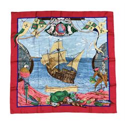 Hermès 'Christophe Colomb Découvre l'Amérique' jacquard silk scarf, designed by Carl de Parcevaux in 1992, limited edition for the bi-centenary of the discovery of America, printed with a central image of Christopher Columbus' ship at sea, surrounded with colourful stylised feathers, birds, flags, globes, shells and flowers, contained within vibrant red border, with rolled hand stitched edges and Hermes material label, 87cm square