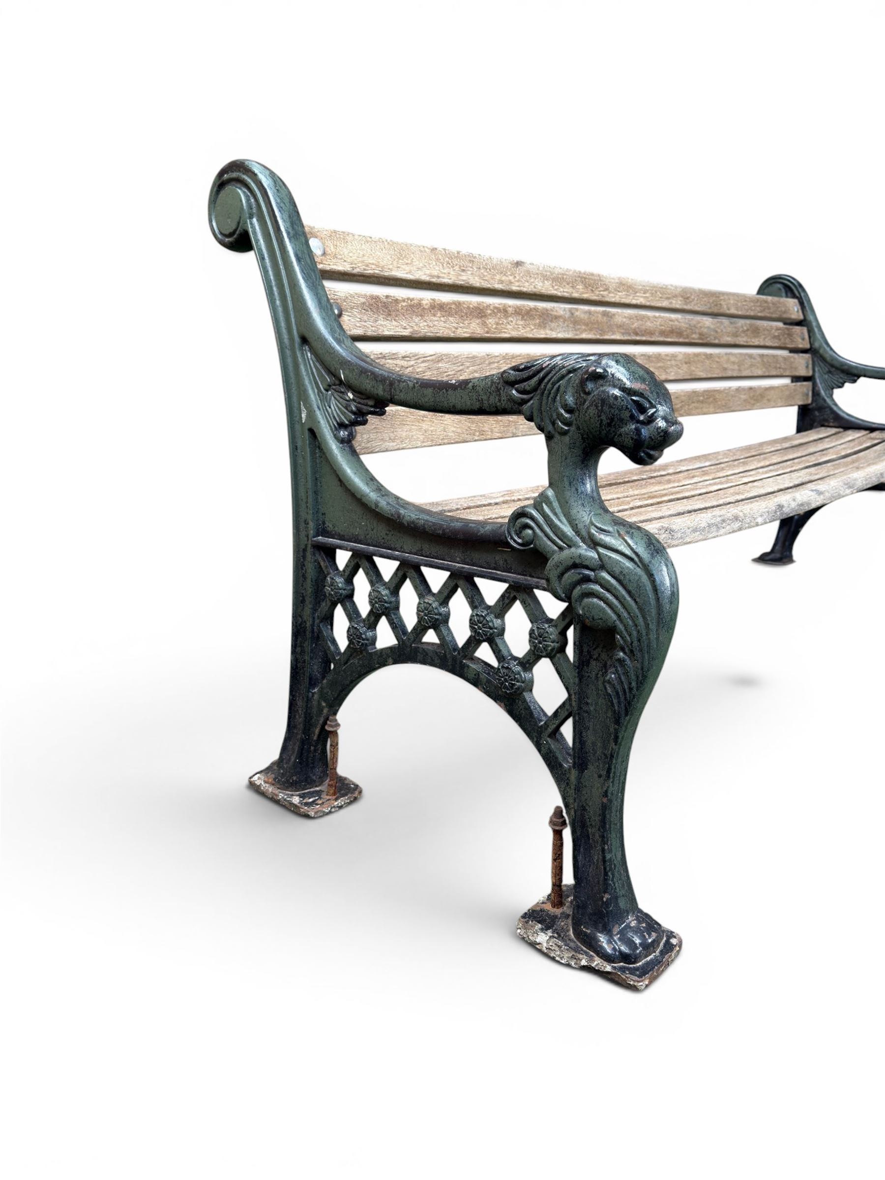 Neoclassical design cast iron and oak slatted garden bench, the twin end supports in the form of a Sphinx with acanthus carved knees and large paw feet, the pierced lattice bracket with Yorkshire rose motifs