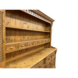 Large traditional pine dresser, projecting reeded cornice over two tier plate rack fitted with eight spice drawers, flanked by rope-twist upright pilasters and foliate carved scrolled corbels, the base fitted with four drawers and two double cupboards 