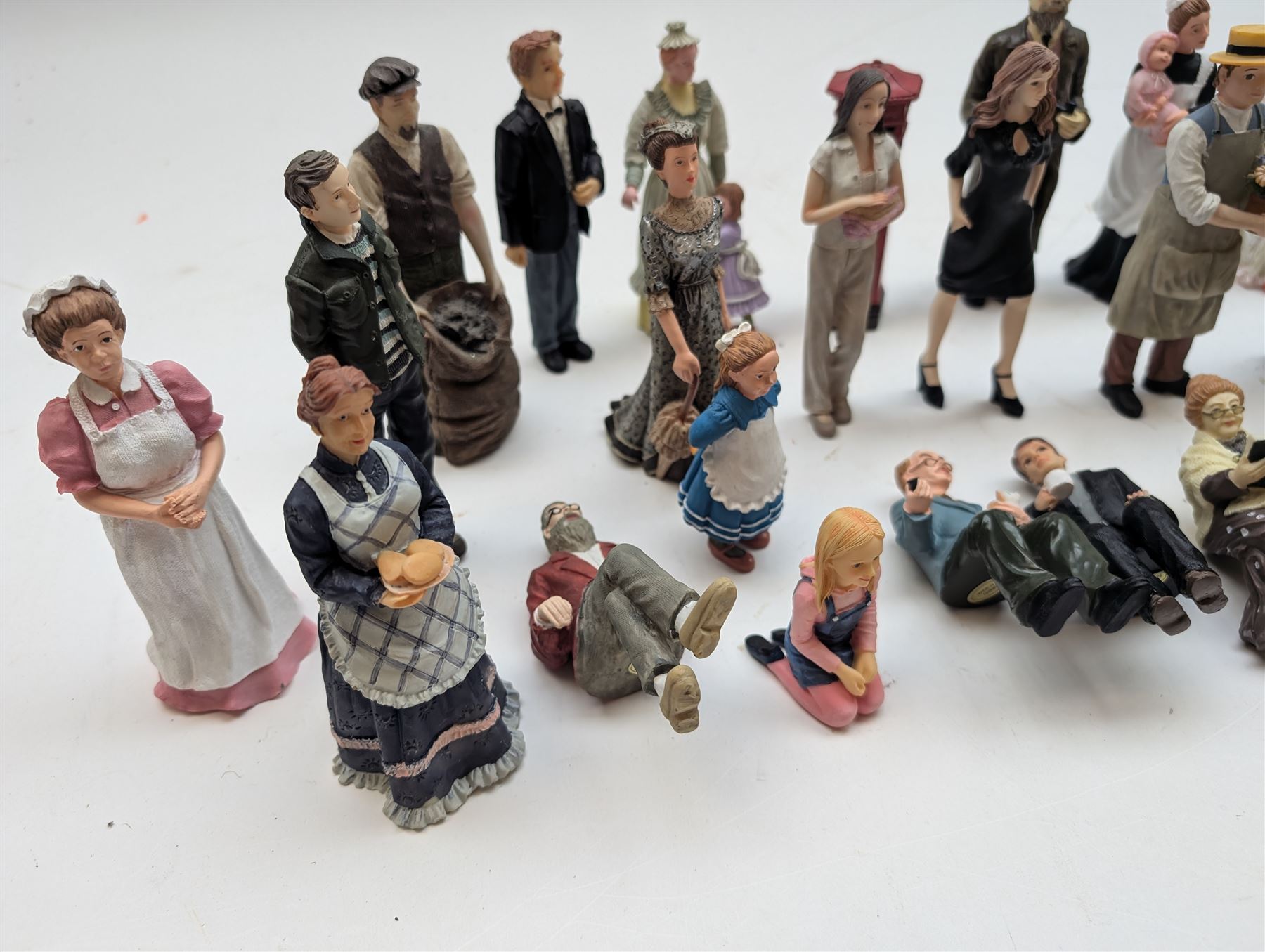 1:12 scale dolls house composite figures, including policeman, postman, maid, sitting and standing people in various styles of dress, etc
