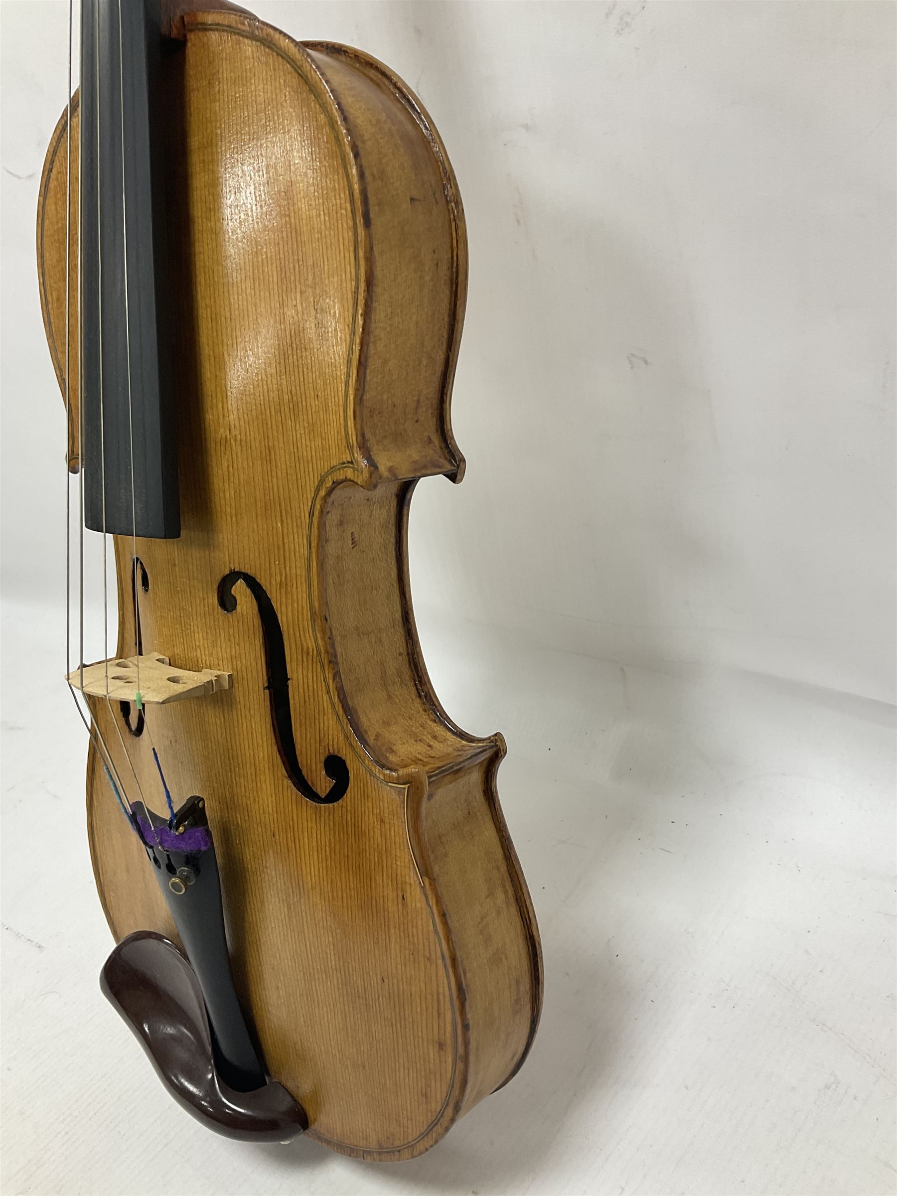 Copy of a full size Stradivarius violin, with an ebonised fretboard, tailpiece and tuning pegs, with a polished chin rest  Length 60cm