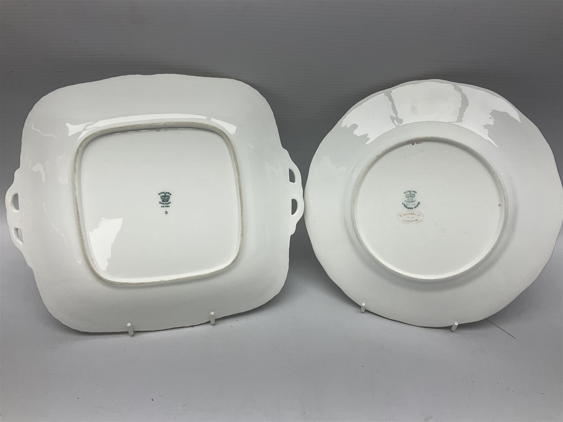 Coalport cobalt blue batwing pattern tea wares, decorated with finely enamelled floral sprays within gilt reserves, comprising teacup trio, coffee can and saucer and other cup and saucer, twin handled cake plate, milk jug and open sucrier, and circular plate retailed by T. Goode & Co London, pattern no Y2665,  all with green Coalport AD 1750 marks beneath, largest W26cm (11)