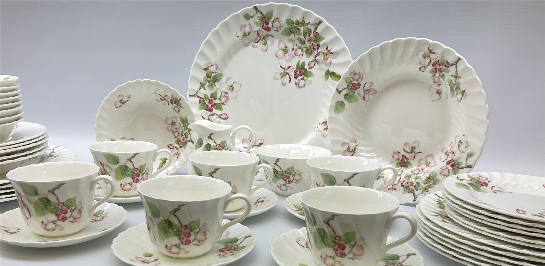 Wedgwood Apple Blossom pattern dinner and tea wares, comprising six dinner plates, six side plates, six bowls, nine smaller bowls, six tea cups and six saucers, milk jug and open sucrier. 
