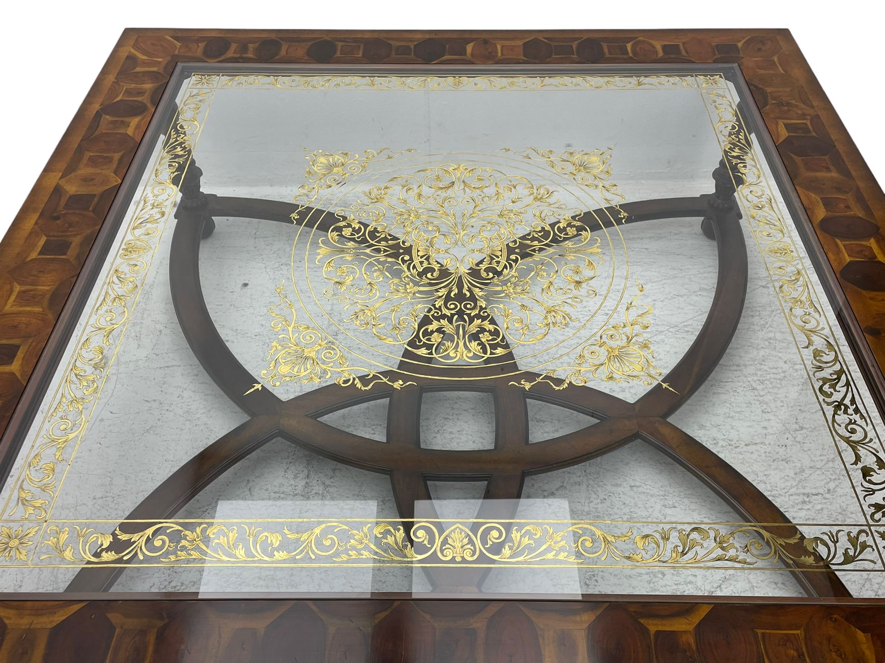 Jonathan Charles - large mahogany coffee table, the square oyster veneered top with verre églomisé inset, the glass hand-painted with gilt scrolling foliate patterns, raised on spiral turned supports with acanthus and gadroon carvings, united by interlocking demi-lune stretchers, on scrolled acanthus feet