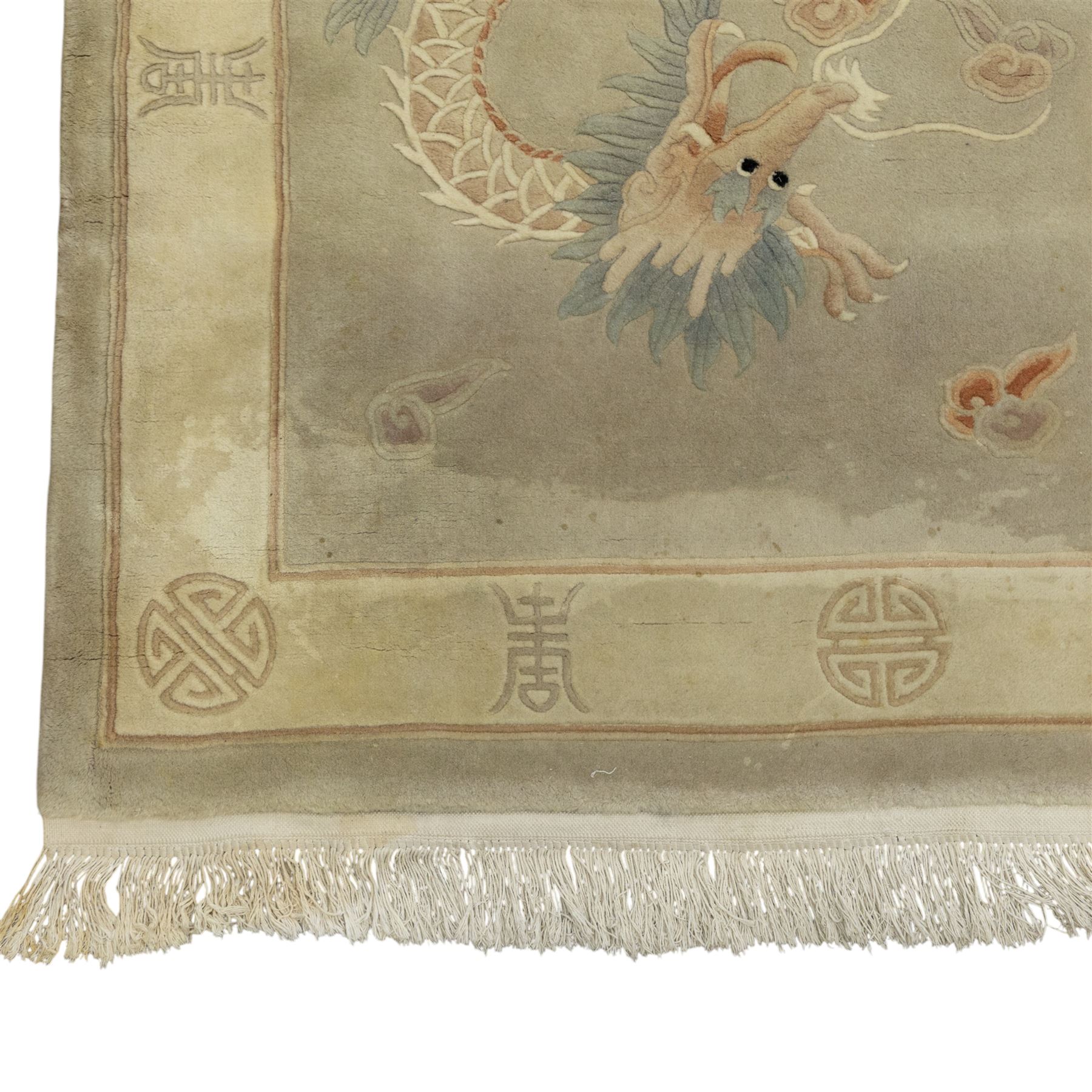Chinese wool rug, the pale grey central field decorated with two stylised dragons, flaming pearls and cloud scrolls, within a cream border of shou medallions and geometric motifs, with cotton fringe ends