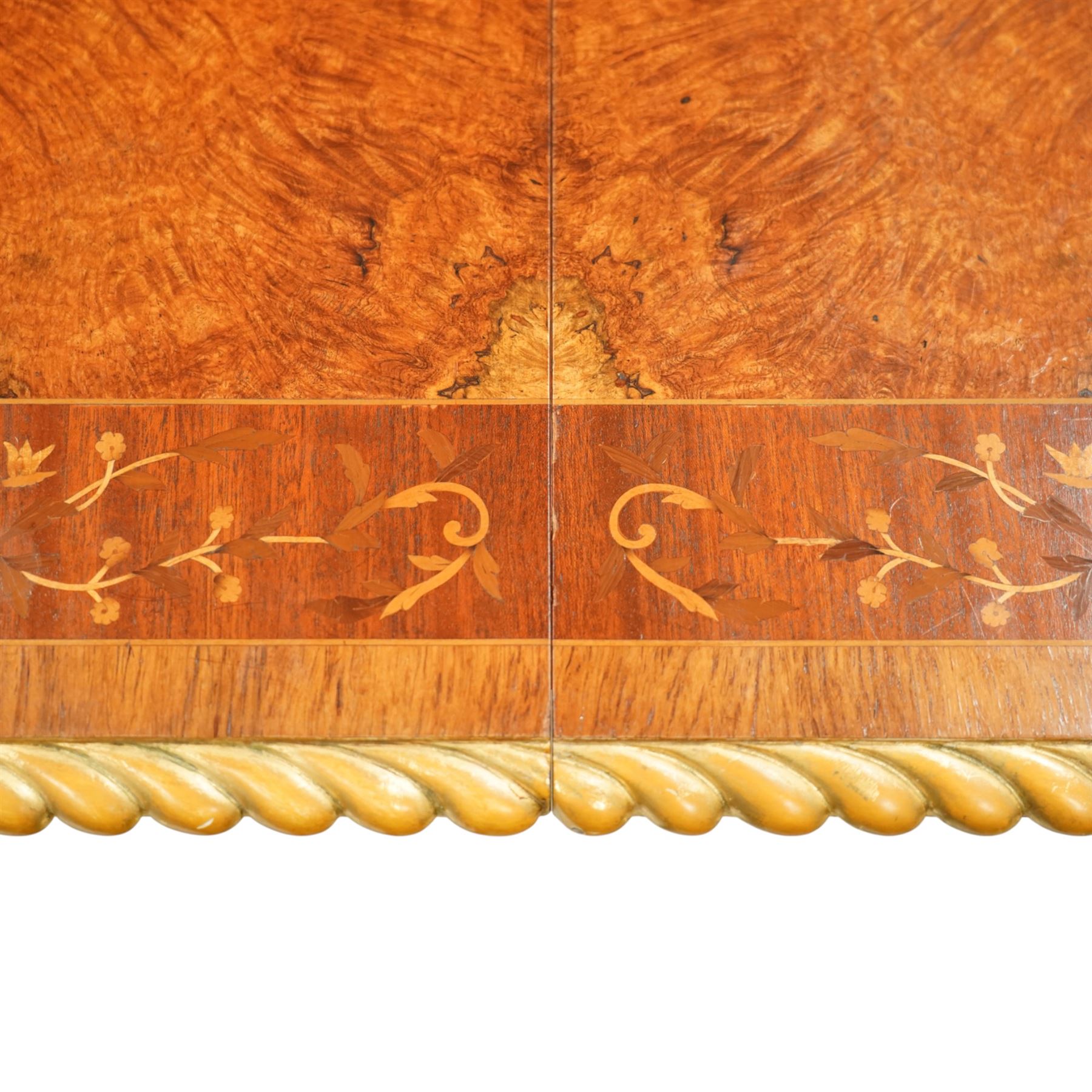 Arthur Brett & Sons - late 20th century twin pedestal dining table in the Second Empire style, the oval Amboyna burl veneered top, bordered with tulipwood crossbanding and delicate floral marquetry inlay, and rosewood crossbanded outer border within gilt gadrooned edge, over two mahogany triform pedestal bases with rosewood crossbanding and decorated with neoclassical marquetry of tied ribbons, leafy sprays, and scrolling acanthus decoration, raised on carved and gilded lion paw terminals on plinth bases, underside with maker's label