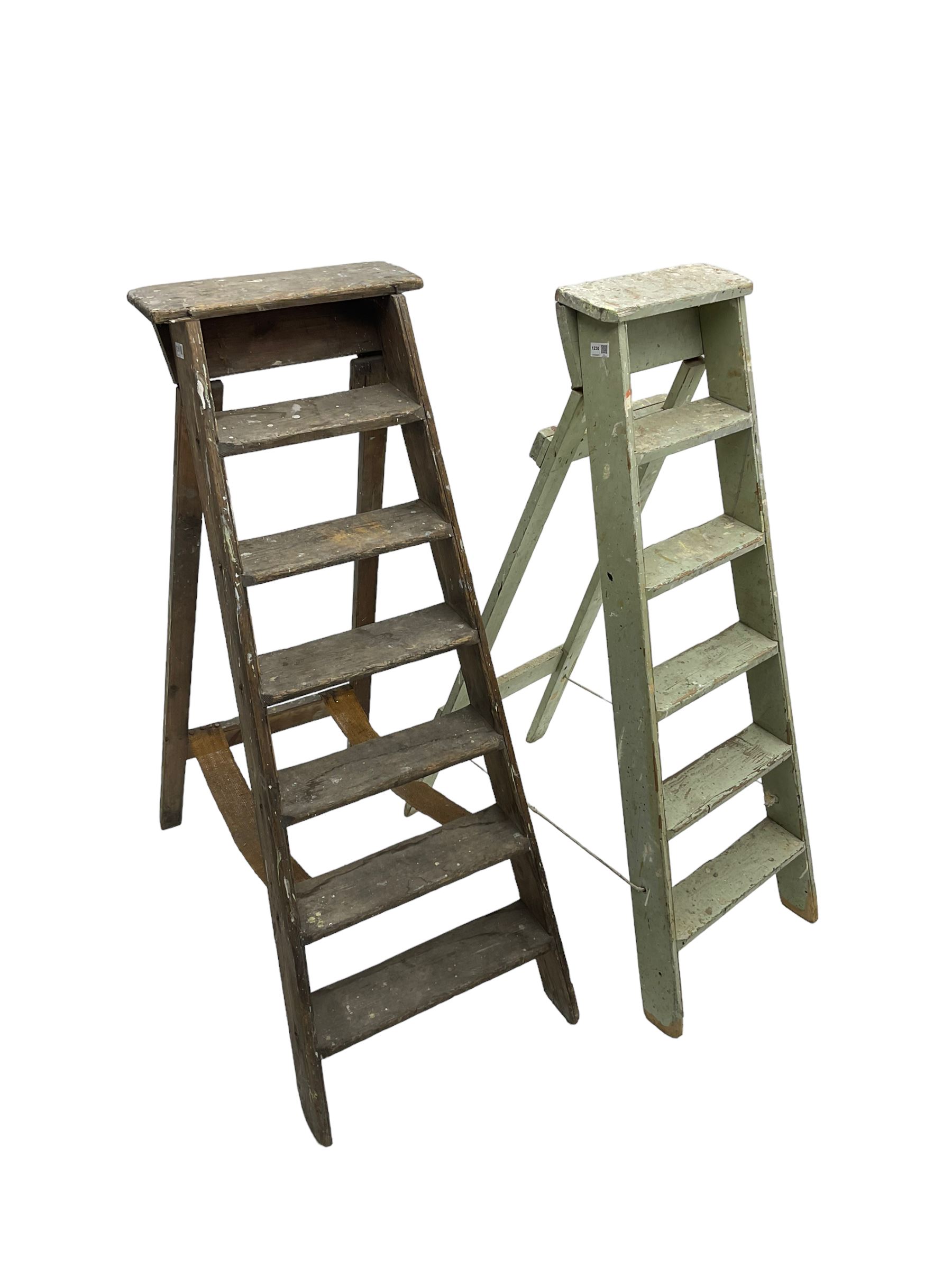 Early 20th century pine library or shop step ladder, seven tread (W45cm H135cm); together with another similar with painted laurel green finish (H135cm)