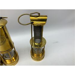 Four miners lamps, comprising Clanny miners lamp, with flip top and gauze protected by three rods, stamped E.T.W E-3, lamp with a gauze chamber protected by three rods, and two E. Thomas & Williams Ltd lamps, tallest example H26cm