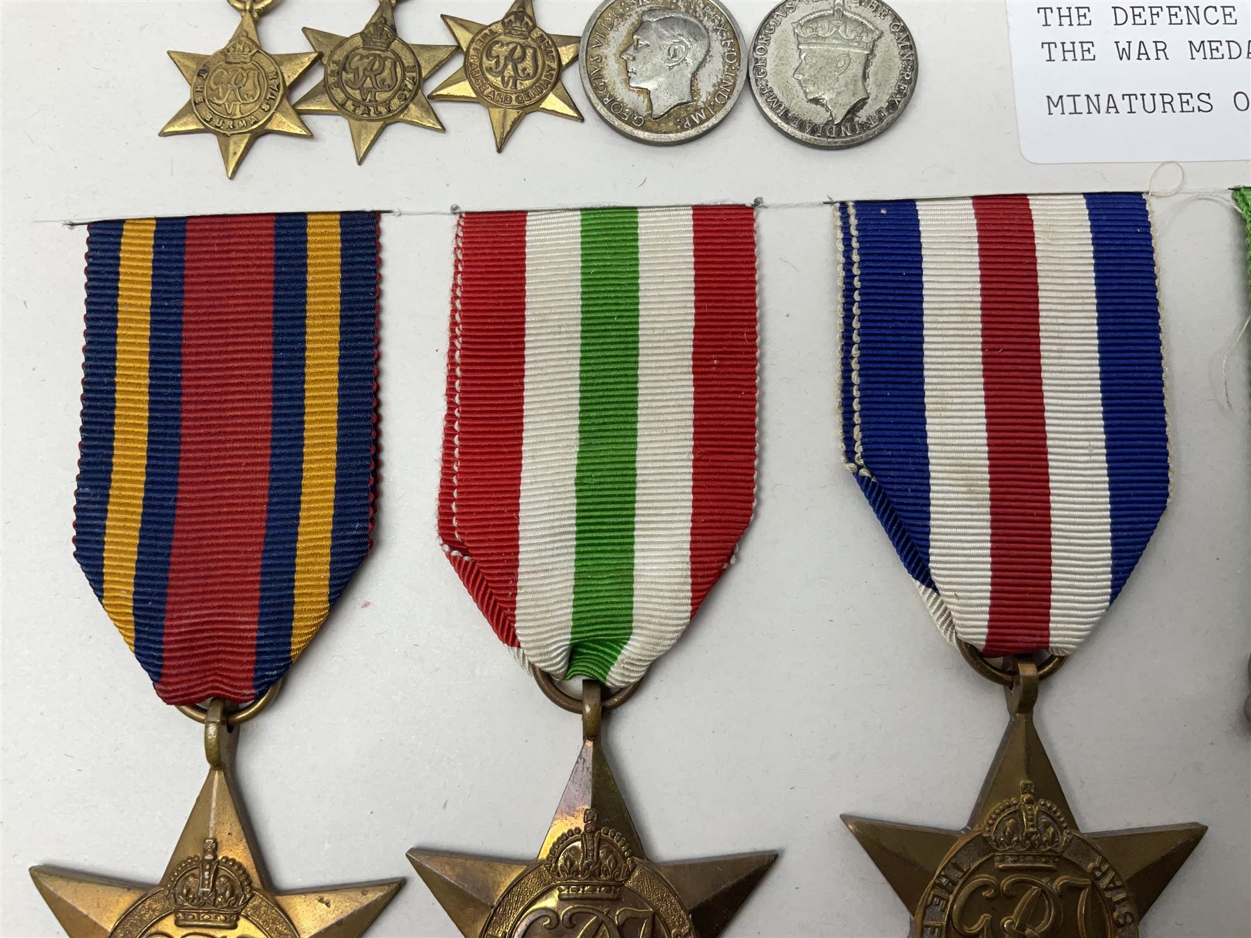Representative display of WWII Campaign Stars and Medals comprising Burma Star, Italy Star, France & Germany Star, Defence Medal and War Medal 1939-1945; together with the corresponding group of miniatures; all with ribbons