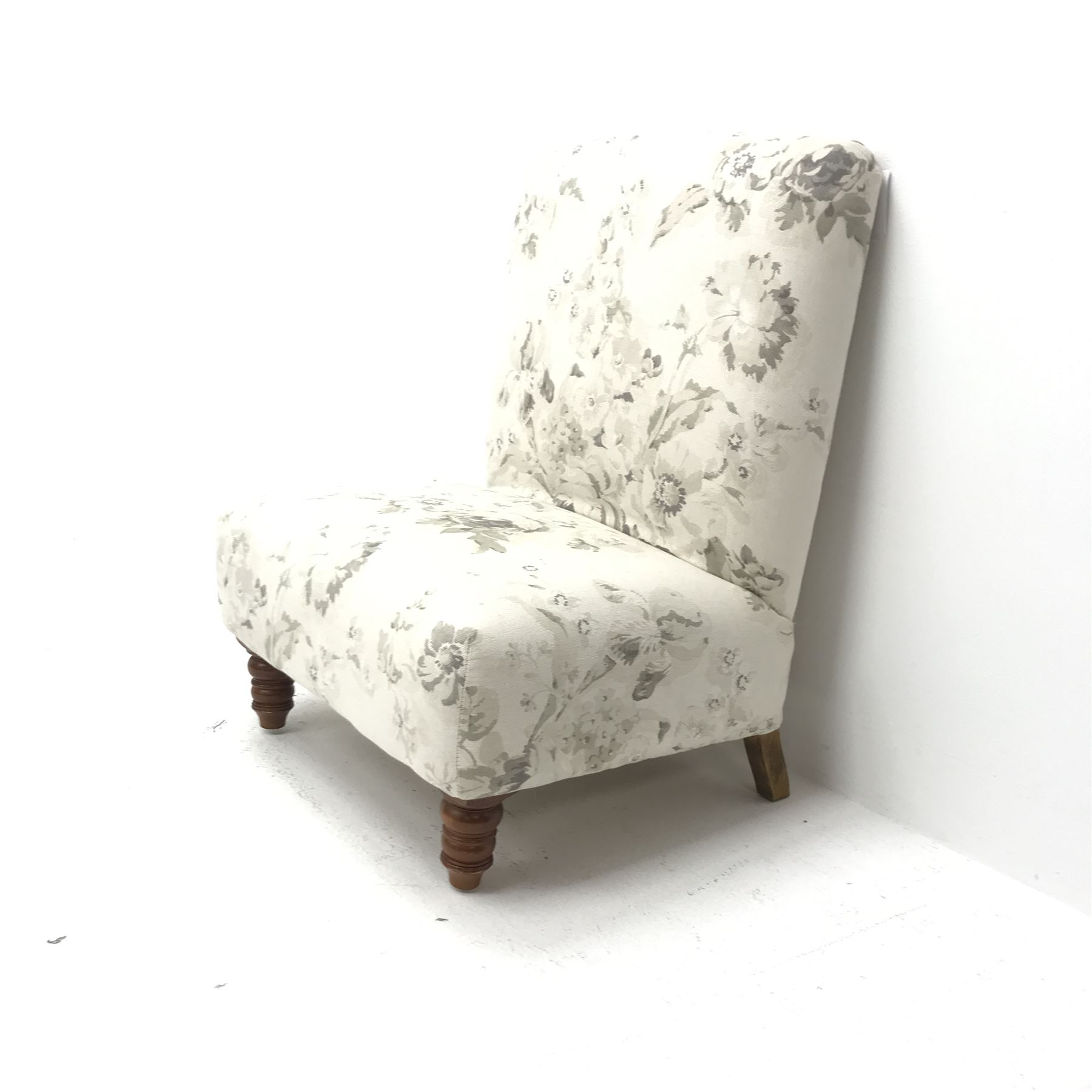 Wide seat nursing chair upholstered in an ivory ground fabric with floral pattern, turned supports, W63cm