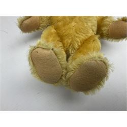Steiff teddy bear with golden plush body, revolving head, applied eyes, vertically stitched nose and mouth and jointed limbs; button to left ear H26cm; and two other Steiff teddy bears, each with open mouth and button with tag to left ear (3)
