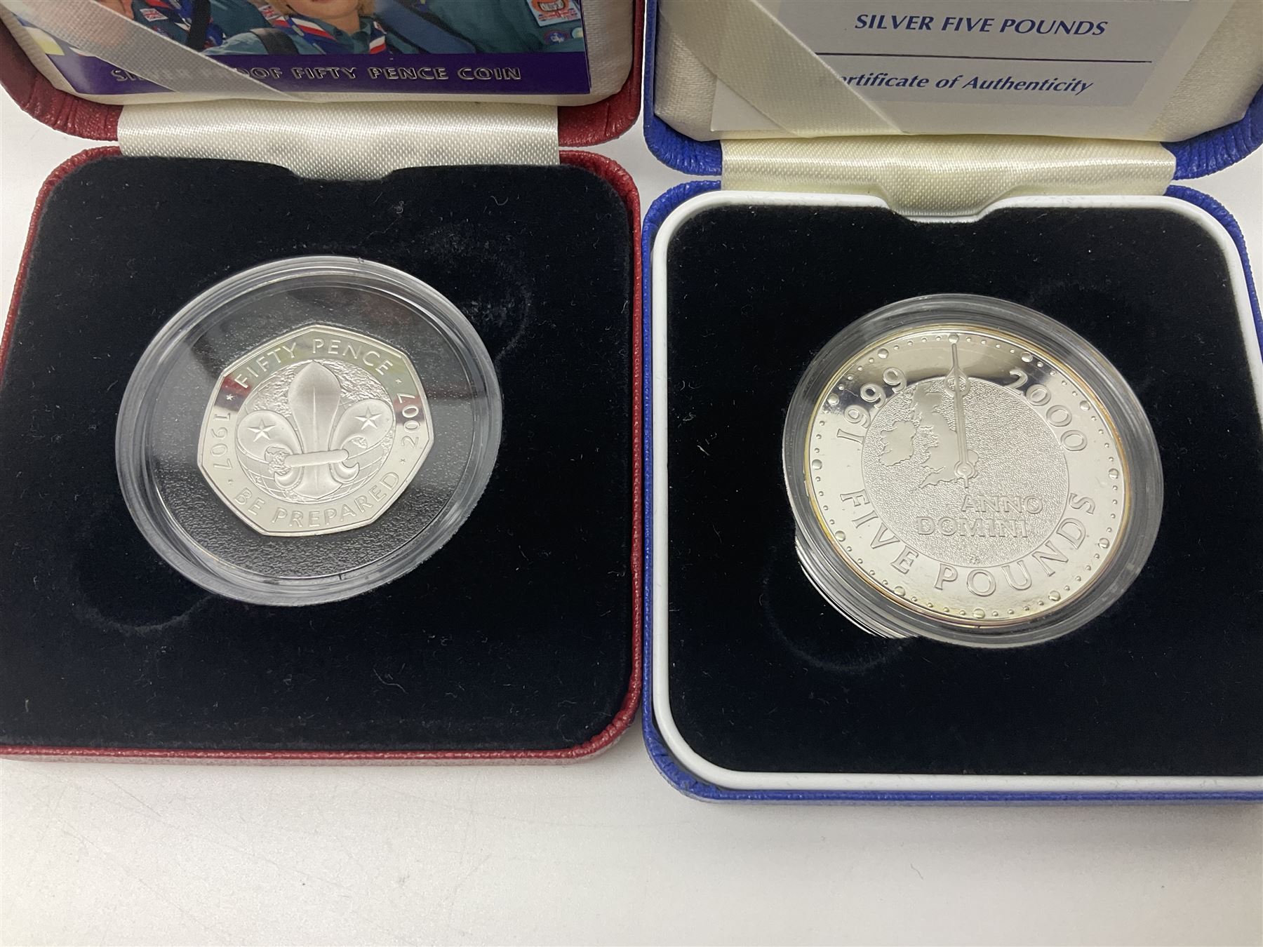 Queen Elizabeth II 2000 'The Queen Mother' silver proof five pound coin, 2000 'Millennium' silver proof five pounds, 2007 'Scouts' silver proof fifty pence, Tristan Da Cunha 2014 9ct gold 1 gram gold one crown coin, all cased with certificates and a 'Prince Charles 60th Birthday Commemorative Coin Cover' containing a 2008 silver proof five pound coin in folder (5)