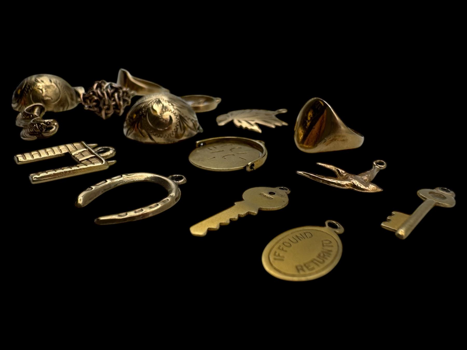 9ct gold charms, including crossed swords, signet ring, horseshoe and leaf, and a 14ct gold fireplace charm