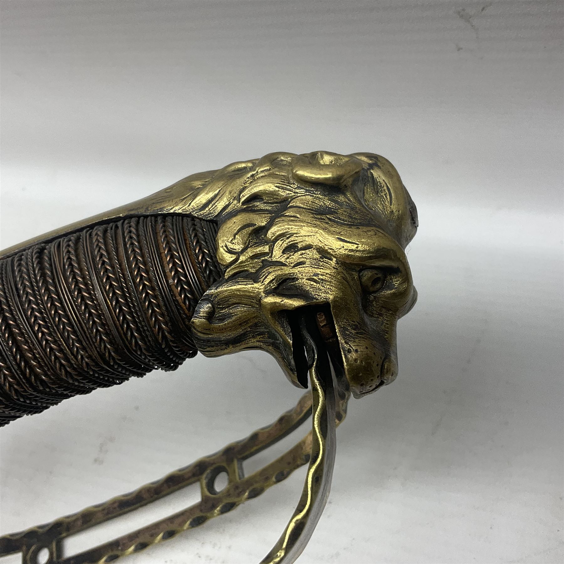 Late 18th century French 1st Empire Troupe a Pied Petit Montmorency Branch Tournante officer's sword, with 72.5cm slightly curving fullered blade, pierced brass hilt with lockable swivelling bar, fully wire-bound grip with lion head pommel, L88cm overall (no scabbard)