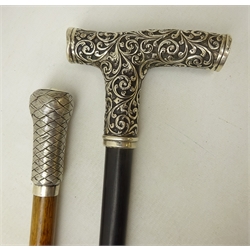  19th/ early 20th century mahogany walking cane with woven white metal wire work pommel, the top inscribed John Needliam, L83cm and an similar age ebonised walking cane with embossed handle (2)  