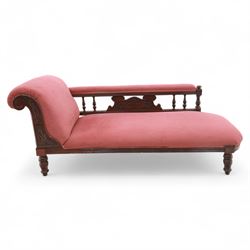 Late Victorian mahogany chaise longue, of scroll-ended form, upholstered in red diamond-patterned fabric with padded back and scroll-carved support, open arm with carved foliate and turned upright, raised on turned tapering legs 