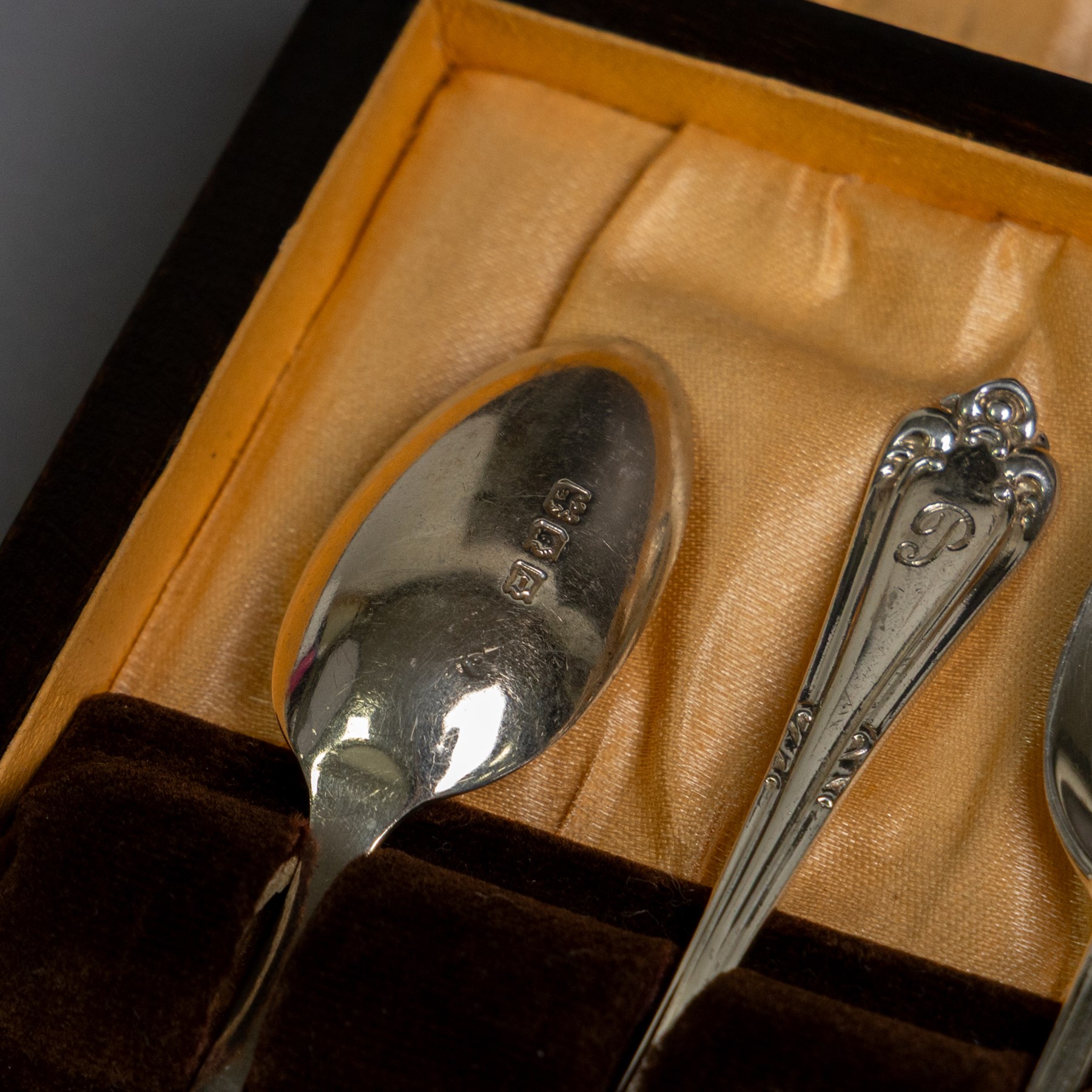 Two sets of early 20th century cased silver coffee spoons, comprising a set of six with scrolling decoration and engraved initials and a set of six coffee bean spoons, all hallmarked 