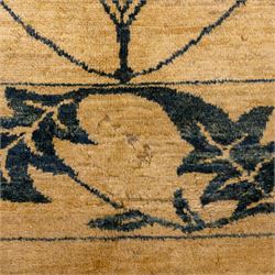 Late 20th century Turkish hand-woven carpet, golden beige field decorated with a repeating lattice of stylized medallions enclosing boteh and angular foliate motifs linked by issuing scrolling vinery within a border of complementary stylized leaf scrolls