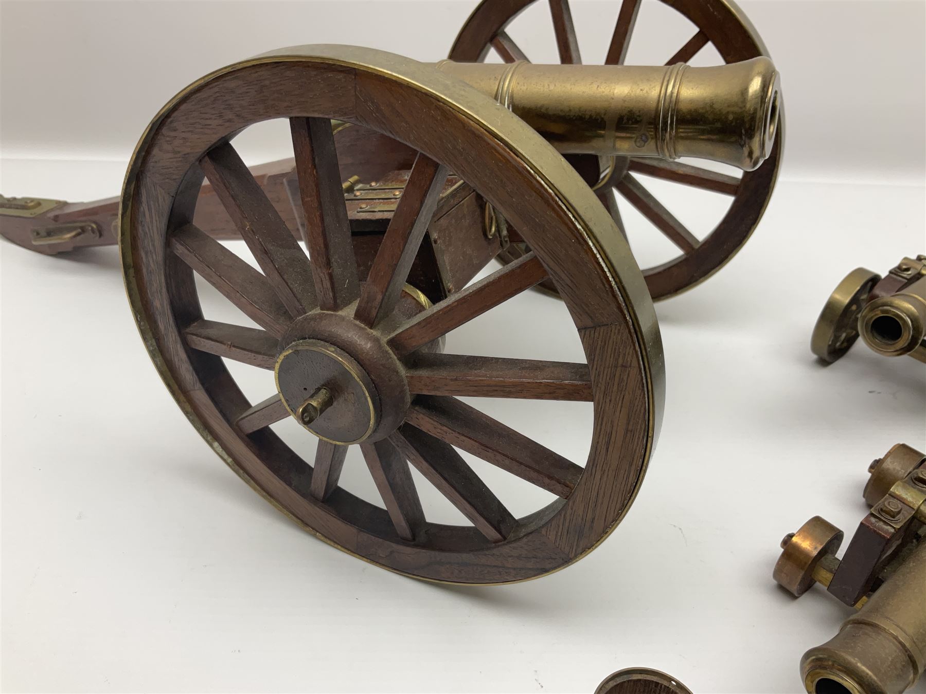 Large model brass cannon, upon wooden base, together with two similar smaller cannons, largest L48cm