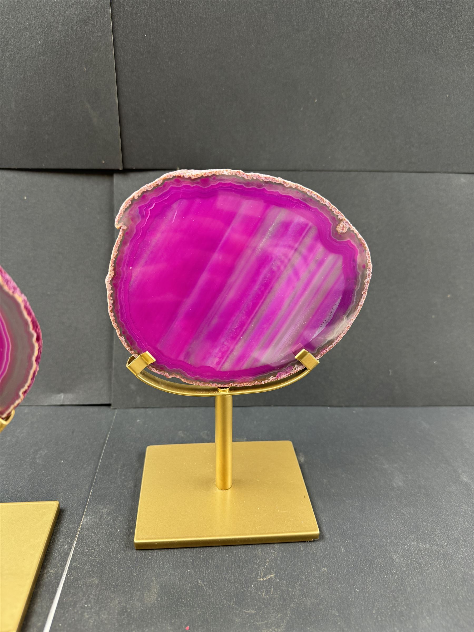 Pair of pink agate slices, polished with rough edges, raised upon gilt metal stands, H20cm