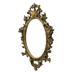Large 19th century Florentine style oval mirror in carved giltwood and gesso frame, cartouche pediment over shell surround, decorated with foliate c-scrolls and flower heads