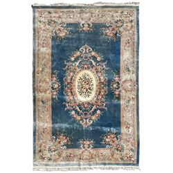 Large Chinese blue ground woollen carpet, overall floral design, central oval medallion surrounded by scrolling floral decoration, wide border with decorated with floral bouquets 