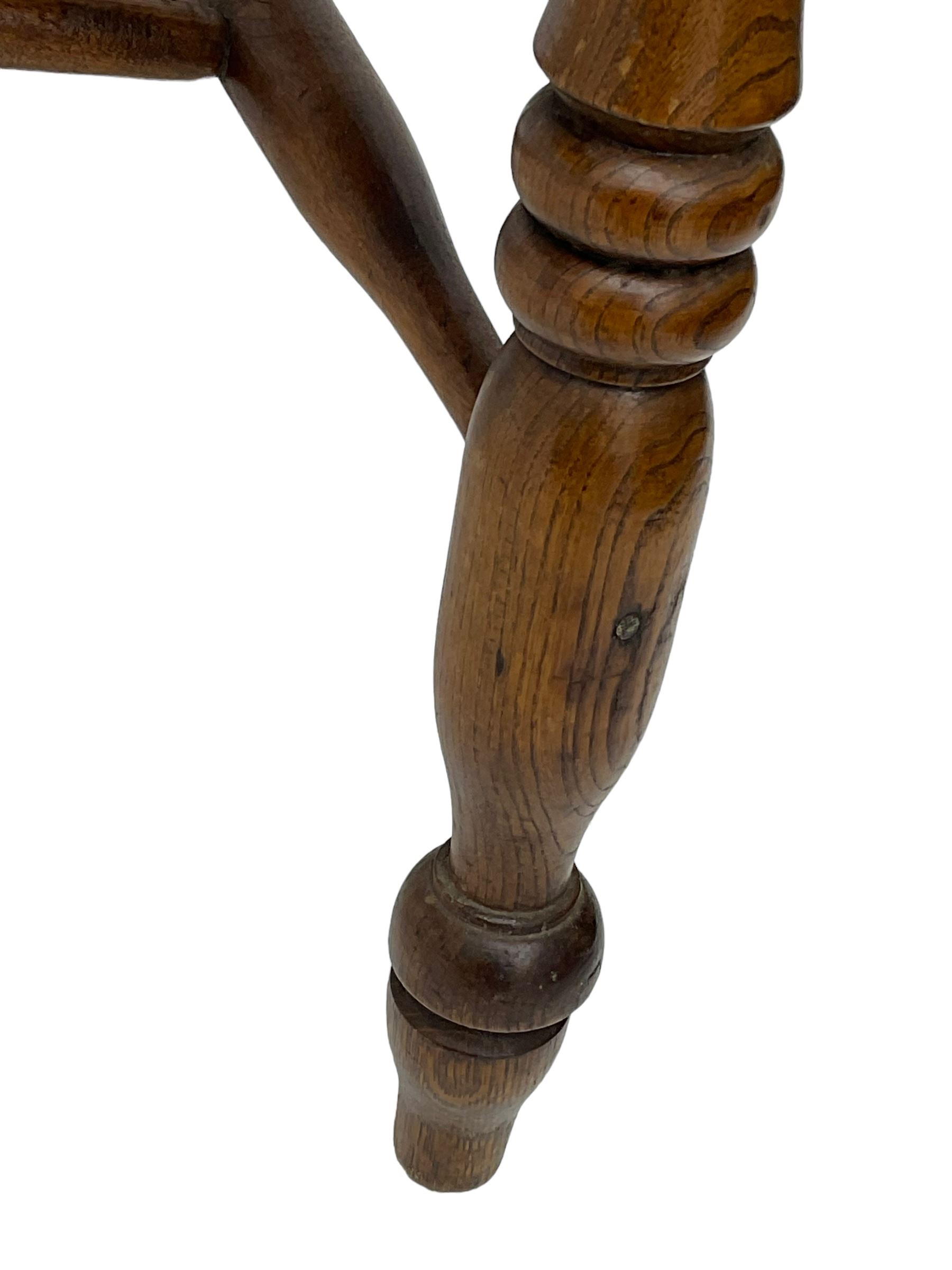 Early 19th century elm farmhouse armchair, the shaped eared cresting rail over tall spindle back, dished seat on turned supports united by H stretchers