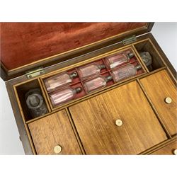 19th century satinwood travelling toilet box with twin drop handles, the hinged cover opening to reveal a compartmented interior with two clear glass bottles with stoppers, six smaller bottles with screw threaded tops, and five divisions, three with covers, two with pull out boxes with sliding covers, H13cm W31cm D25.5cm