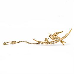 Early 20th century 15ct gold pearl and diamond swallow brooch, the split pearl set bird perched on a crescent moon, holding a leaf set with rose cut diamonds
