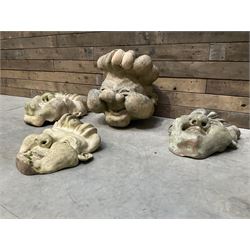Four grotesque garden wall masks