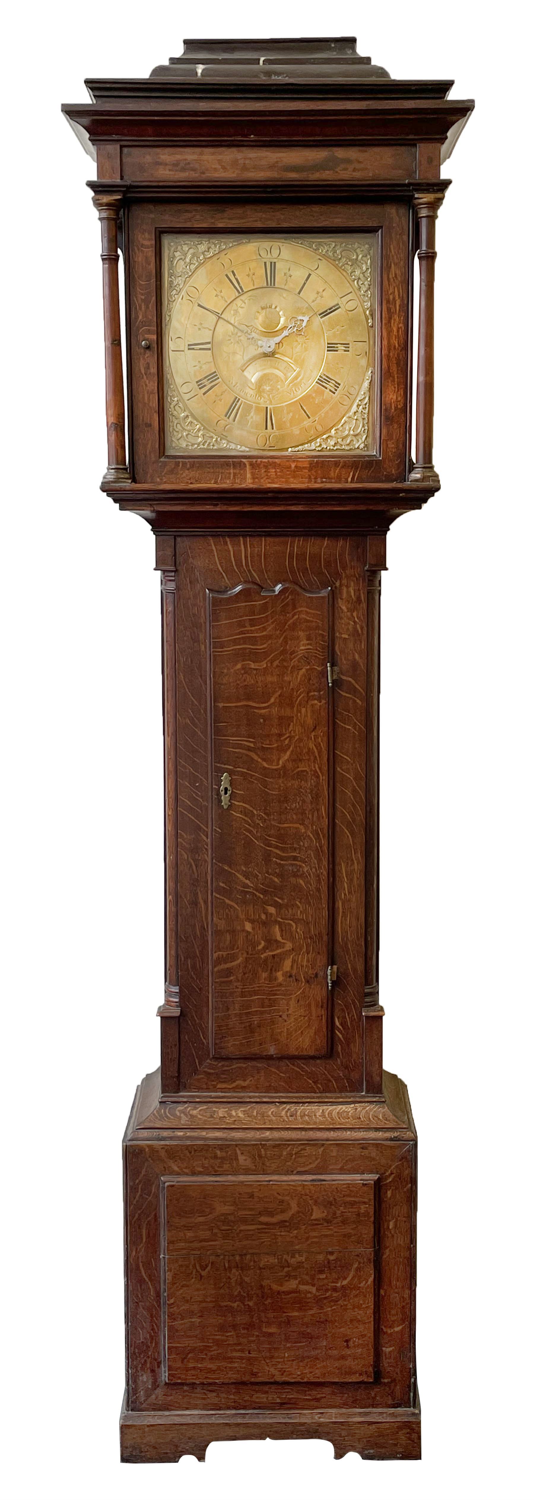 18th century c1760 oak cased George III longcase clock by William Eastwood of Burnley, with a stepped caddy top on a projecting cornice and blind frieze, square glazed door flanked by two turned pillars with gesso capitals, trunk with conforming recessed pillars and a full length wavy topped door, on a square plinth with a raised panel and shaped skirting, 12” square brass dial, 11” chapter ring with Roman numerals and five-minute Arabic's,  