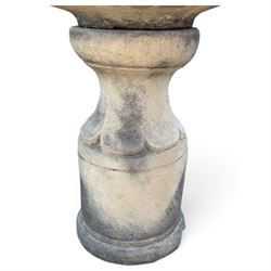 Weathered cast stone garden water feature fountain, the raised central spout with egg-and-dart moulding, within a scalloped basin raised on a lappet pedestal with cylindrical plinth base