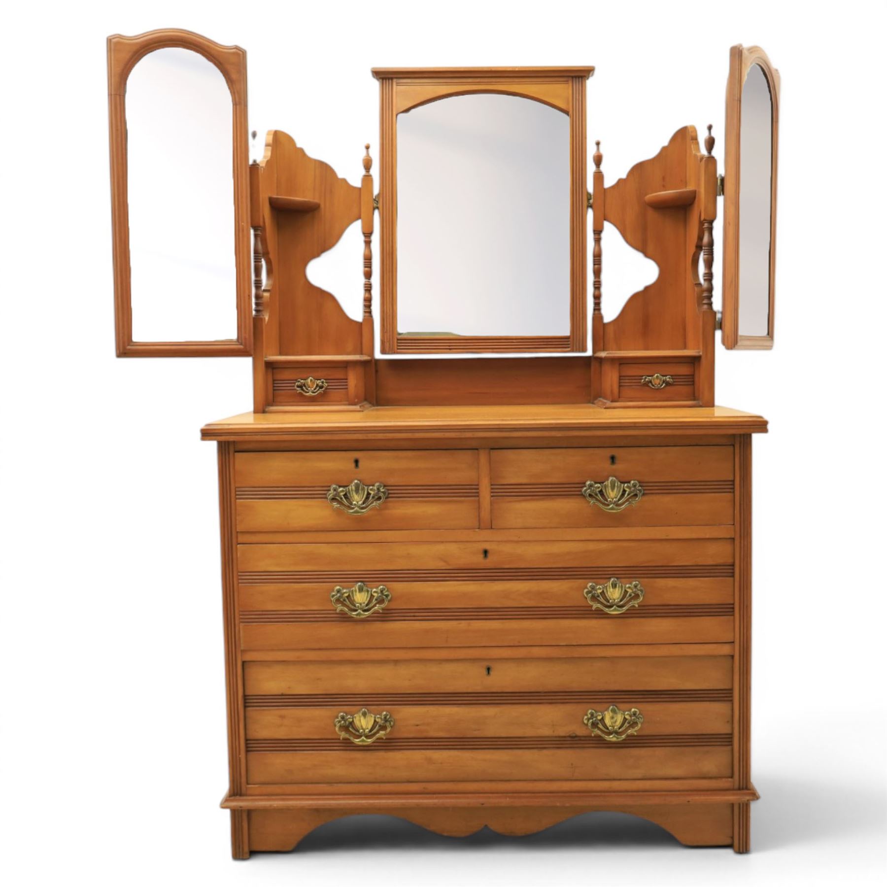 Edwardian satinwood dressing chest, rectangular moulded top over two short and two long drawers with brass drop handles, raised mirror back with arched central plate flanked by hinged side mirrors, small fitted trinket drawers and shaped pierced side supports with turned uprights