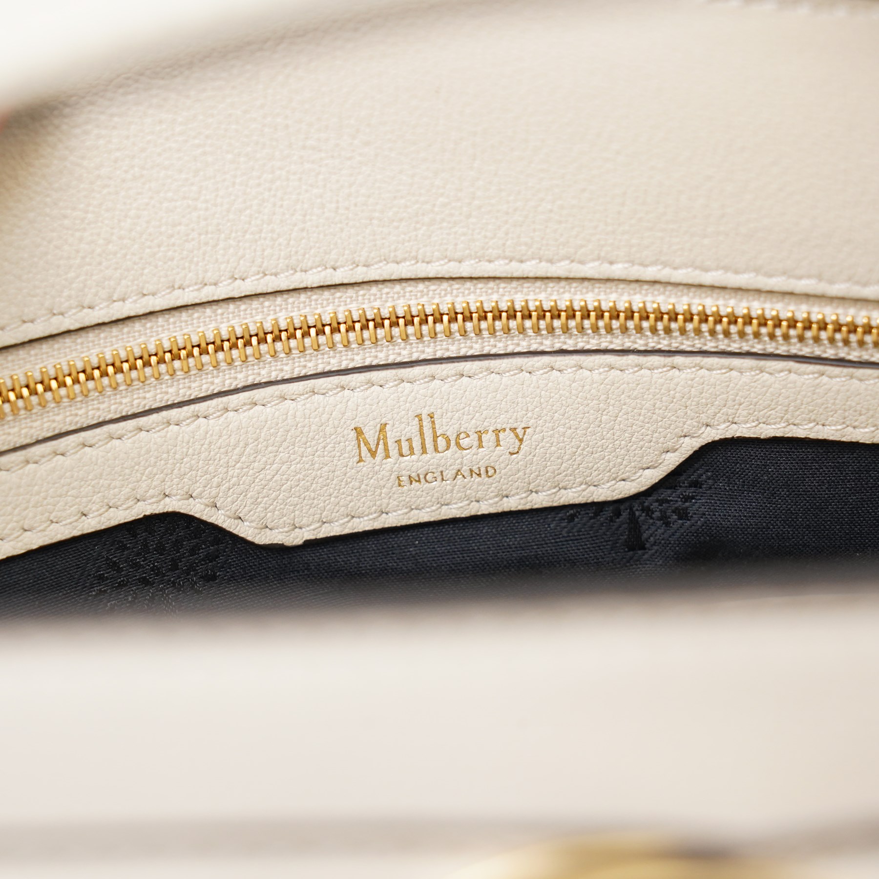Mulberry - Islington handbag in Chalk Silky Calf leather with black piping, the structured body with single rolled top handle, gold-tone Postman’s Lock fastening and front strap detail, with detachable and adjustable shoulder strap, opening to a spacious two-division interior with Mulberry monogram fabric lining, with original Mulberry product tag, care booklet and dust bag, unused